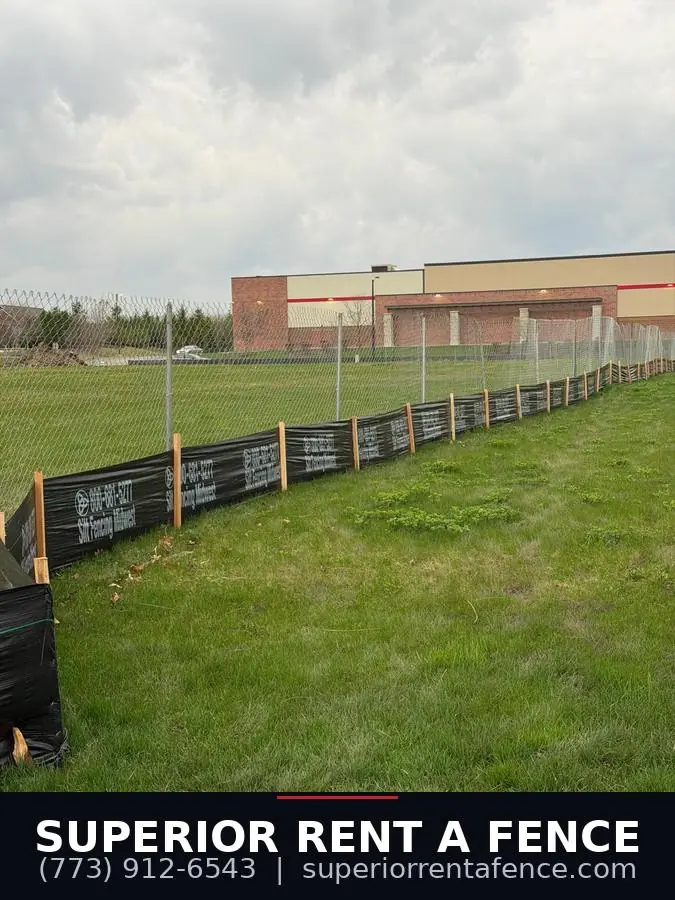 Wide view of chain link fence with silt fence along a commercial construction site
