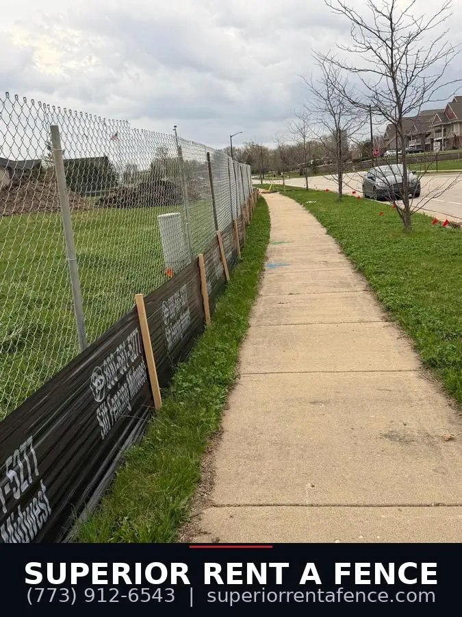 Post-driven chain link fence along a construction site sidewalk