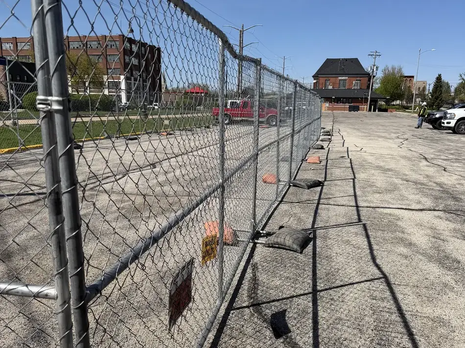 Temporary fence perimeter with Superior Rent-A-Fence signage — barricades and panels are delivered on the same trucks