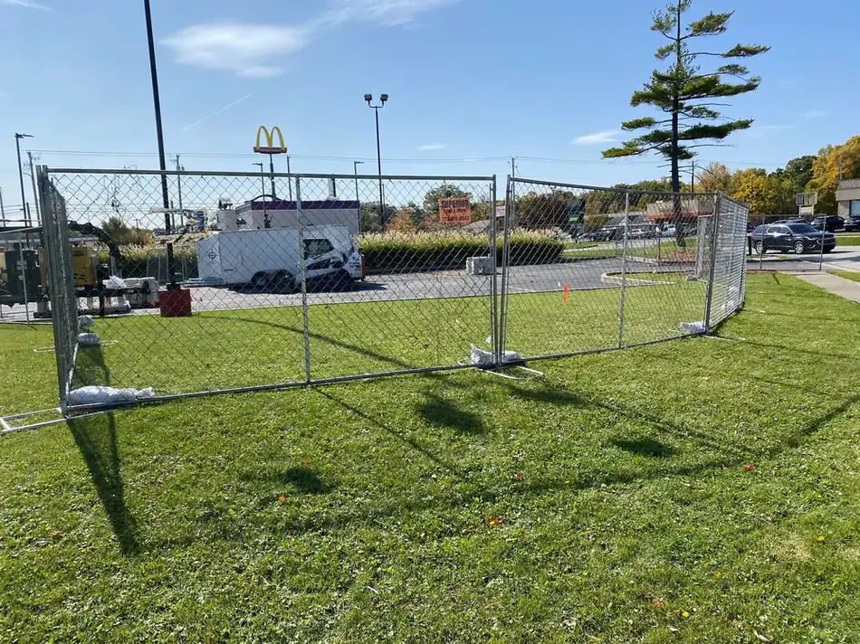 Superior Rent-A-Fence branded panel securing a commercial parking lot